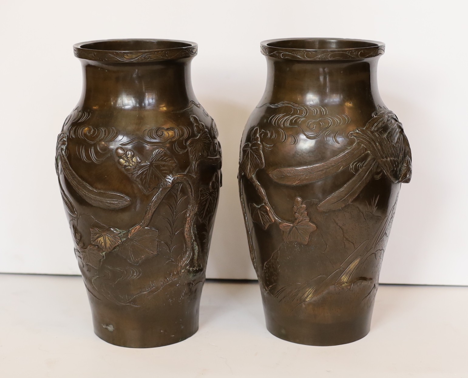 A pair of Japanese Meiji period bronze vases decorated in relief with phoenix, height 27cm